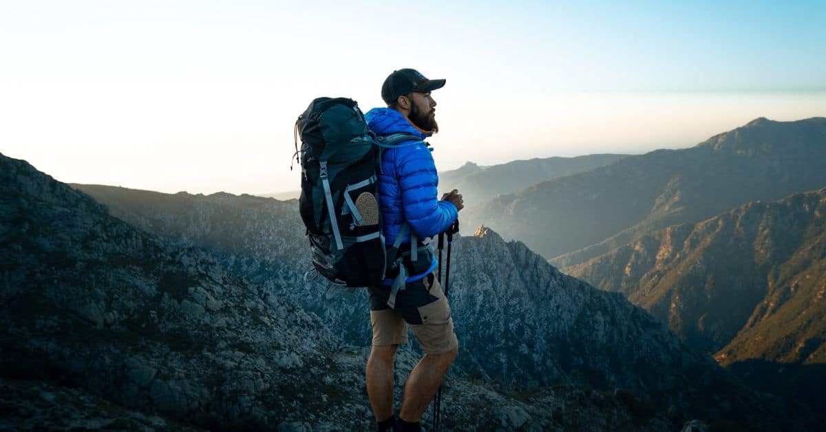 A man standing on a mountain with a 65L backpack